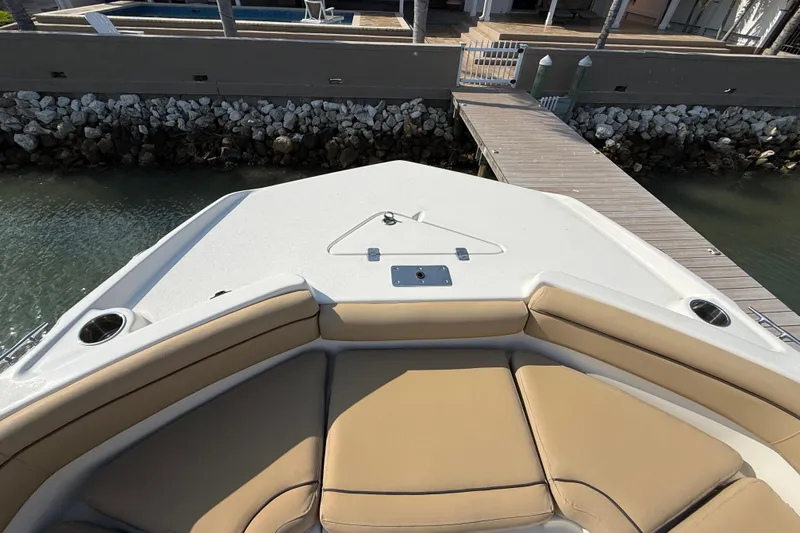 Slide: The Image of 2018 NauticStar 211 Coastal boat bow with tan seating and dock view. - 14