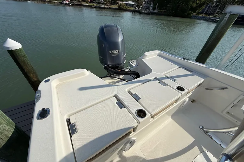 Slide: The Image of 2018 NauticStar 211 Coastal boat with Yamaha 150 engine docked by the water. - 6