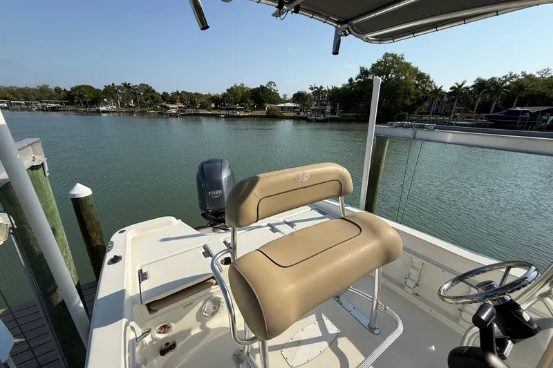 Slide: The Image of 2018 NauticStar 211 Coastal boat with seating, docked by a scenic waterfront. - 7