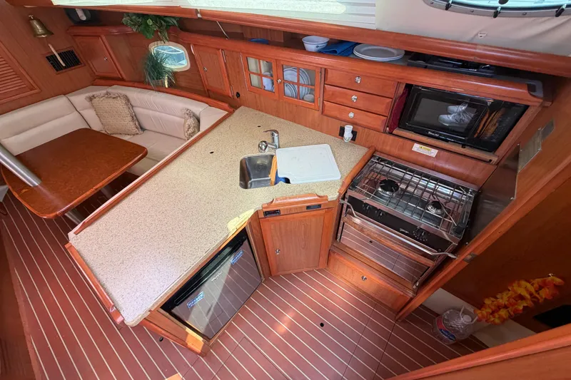 Slide: The Image of Cozy 2008 Hunter 36 yacht interior with kitchen and dining area. - 12