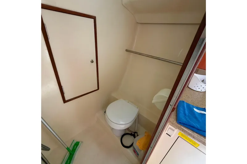 Slide: The Image of Compact bathroom in a 2008 Hunter 36 sailboat, featuring a toilet and storage space. - 27