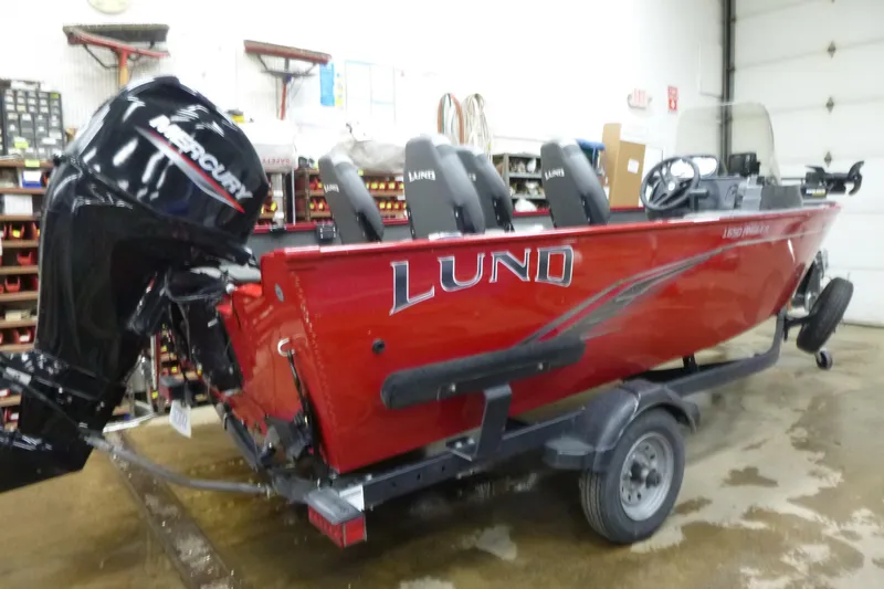 Slide: The Image of 2022 Lund 1650 Angler Sport boat with Mercury engine in a garage setting. - 5