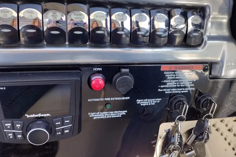 Slide: The Image of Control panel of a 2022 Formula 310 Bowrider boat with switches and warning labels. - 28