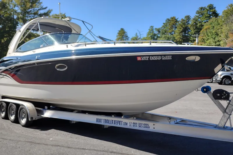 Slide: The Image of 2022 Formula 310 Bowrider on trailer, parked outdoors with trees in background. - 4