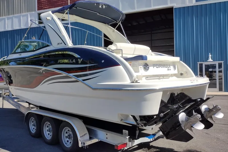 Slide: The Image of 2022 Formula 310 Bowrider boat on trailer, parked outside a blue building. - 7