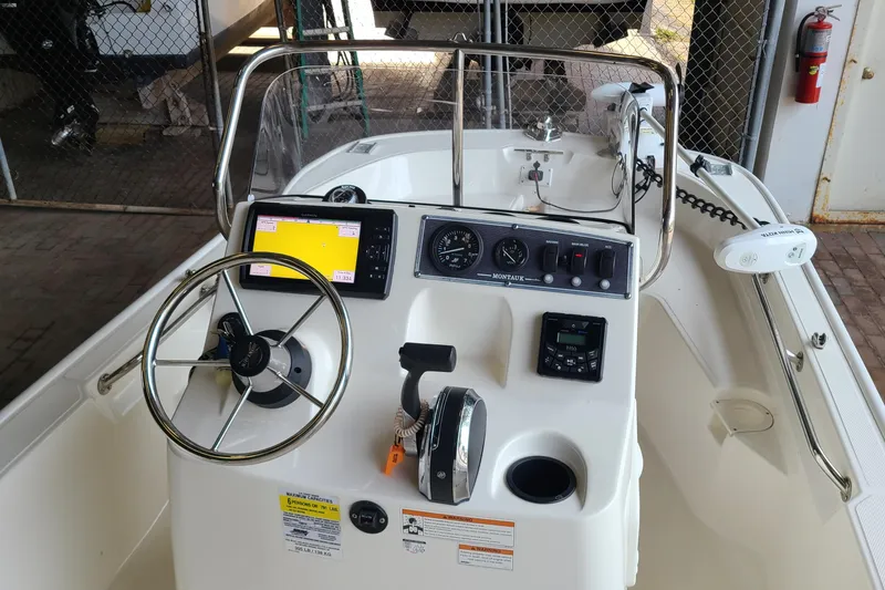 Slide: The Image of 2019 Boston Whaler 150 Montauk boat dashboard with steering wheel and navigation controls. - 11
