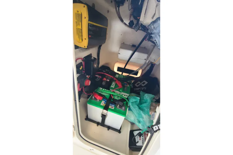 Slide: The Image of 2019 Boston Whaler 150 Montauk storage compartment with battery and equipment. - 14
