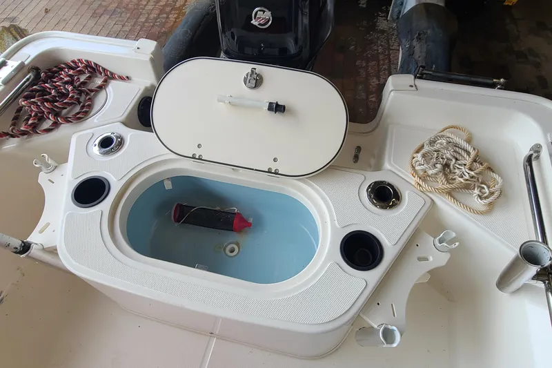 Slide: The Image of 2019 Boston Whaler 150 Montauk boat interior with storage compartment and ropes. - 16