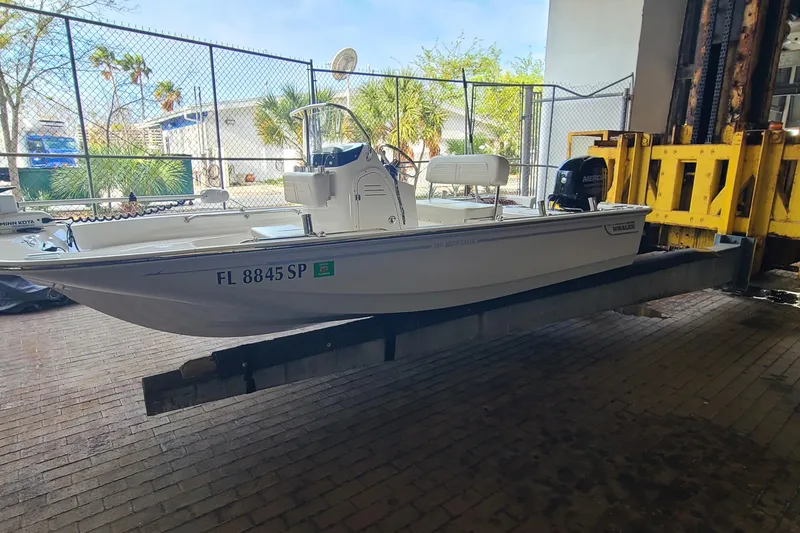 Slide: The Image of 2019 Boston Whaler 150 Montauk boat on a lift, indoors, with registration FL 8845 SP. - 3
