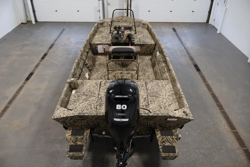 Slide: The Image of 2024 Crestliner 1870 Retriever FCC boat with camouflage design and Mercury 80 engine in a garage. - 10