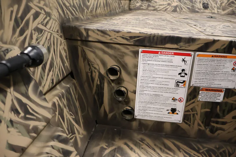 Slide: The Image of 2024 Crestliner 1870 Retriever FCC interior with camouflage design and safety warning labels. - 17