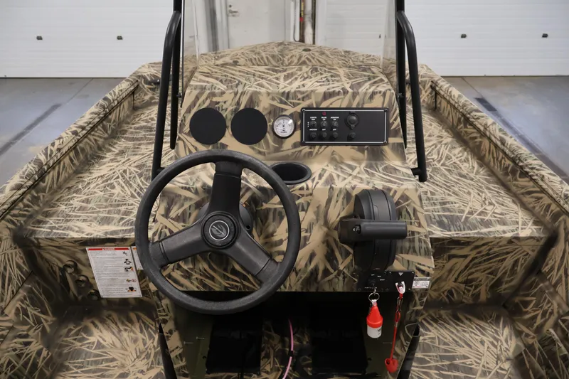 Slide: The Image of 2024 Crestliner 1870 Retriever FCC boat interior with camouflage design and steering console. - 18