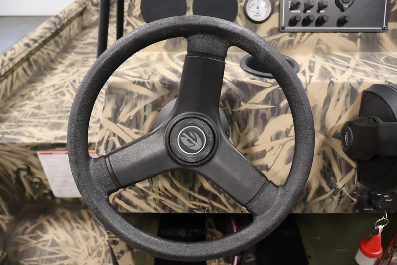 Slide: The Image of 2024 Crestliner 1870 Retriever FCC steering wheel and dashboard with camouflage design. - 19