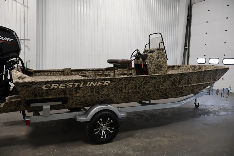 Slide: The Image of 2024 Crestliner 1870 Retriever FCC boat with camouflage design on a trailer in a garage. - 4