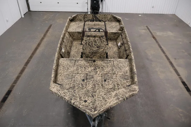 Slide: The Image of 2024 Crestliner 1870 Retriever FCC boat with camouflage interior in a garage setting. - 9