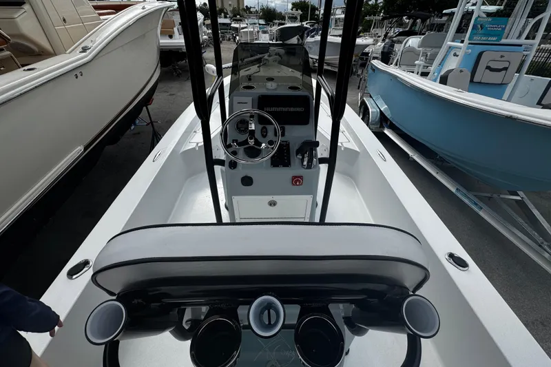 Slide: The Image of 2026 Piranha Casador B2200 boat interior with steering console and seating, docked among other boats. - 9