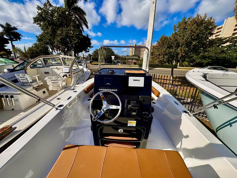 Slide: The Image of 2025 Sea Pro 202 Center Console boat with sleek design, parked outdoors under a blue sky. - 6