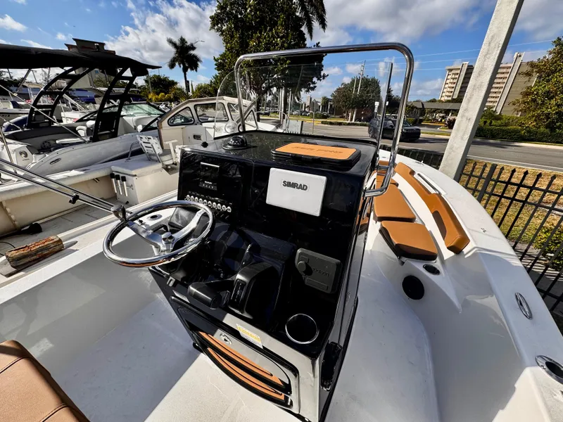 Slide: The Image of 2025 Sea Pro 202 Center Console boat with modern dashboard and seating, docked outdoors. - 8