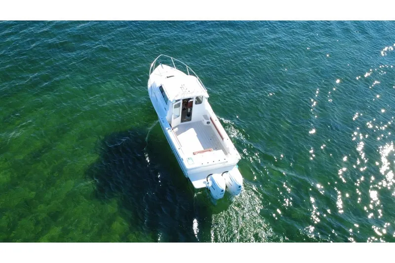 The Image of Aerial view of 2025 Parker 2420 Sport Cabin boat on clear green water. - 1
