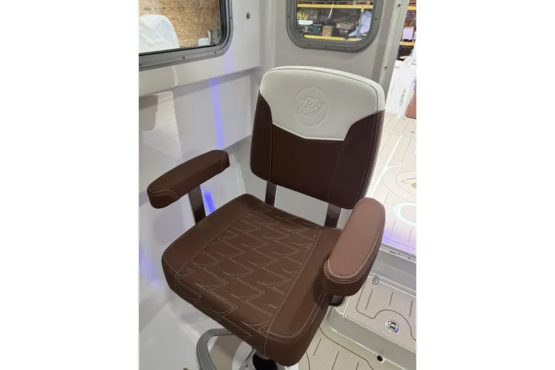 Slide: The Image of Brown and white captain's chair in 2025 Parker 2420 Sport Cabin boat interior. - 11