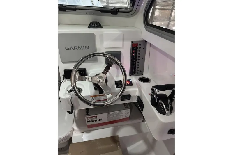 Slide: The Image of 2025 Parker 2420 Sport Cabin boat helm with Garmin navigation system and Yamaha controls. - 13