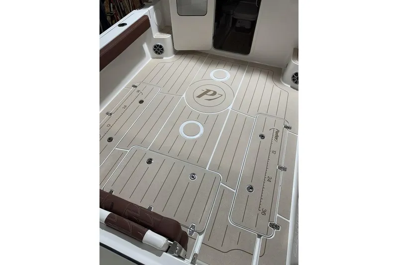 Slide: The Image of 2025 Parker 2420 Sport Cabin boat deck with custom flooring and integrated storage compartments. - 16