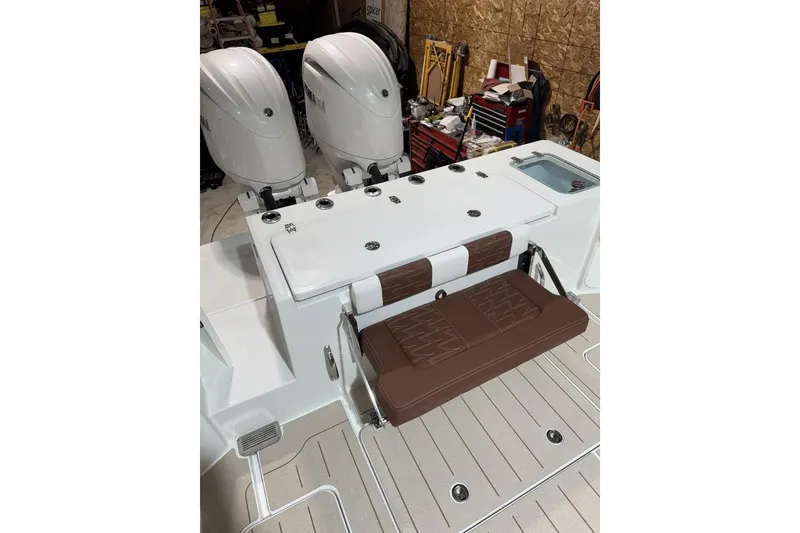 Slide: The Image of 2025 Parker 2420 Sport Cabin boat interior with dual engines and cushioned seating. - 19