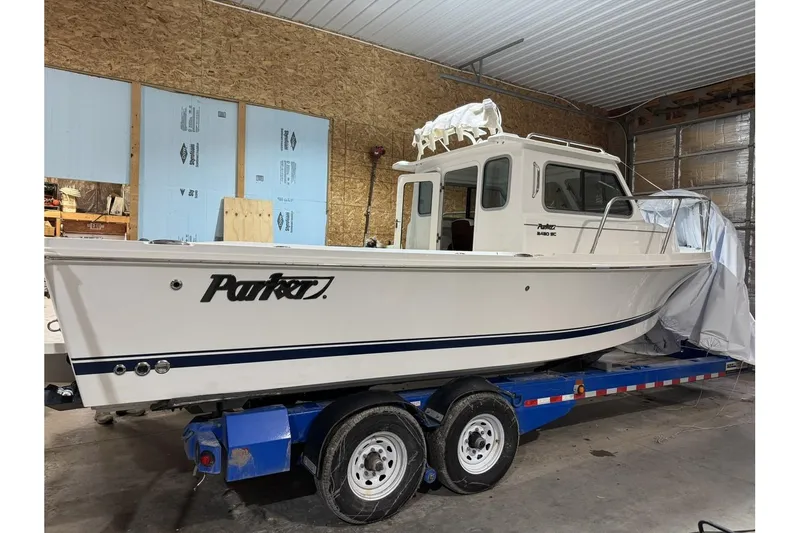 Slide: The Image of 2025 Parker 2420 Sport Cabin boat on trailer in indoor storage. - 24