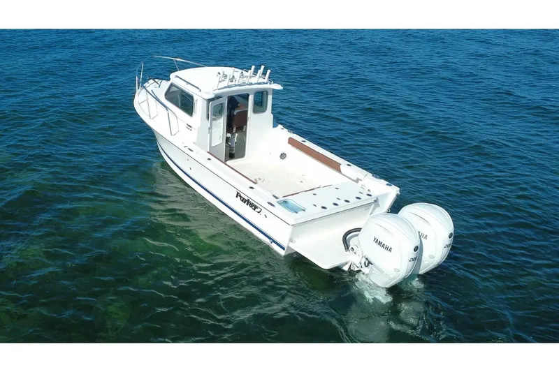 Slide: The Image of 2025 Parker 2420 Sport Cabin boat with twin Yamaha engines on open water. - 3