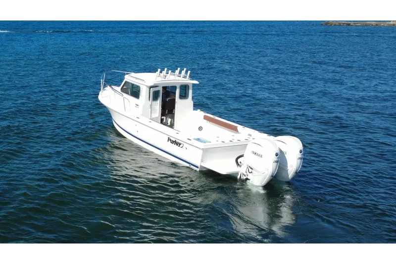 Slide: The Image of 2025 Parker 2420 Sport Cabin boat on open water, featuring twin Yamaha engines. - 4