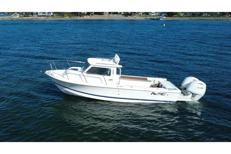 Slide: The Image of 2025 Parker 2420 Sport Cabin boat cruising on open water. - 5