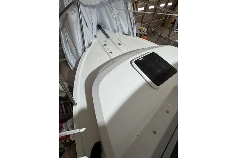Slide: The Image of 2025 Parker 2420 Sport Cabin boat deck in storage, featuring sleek design and sturdy railings. - 8