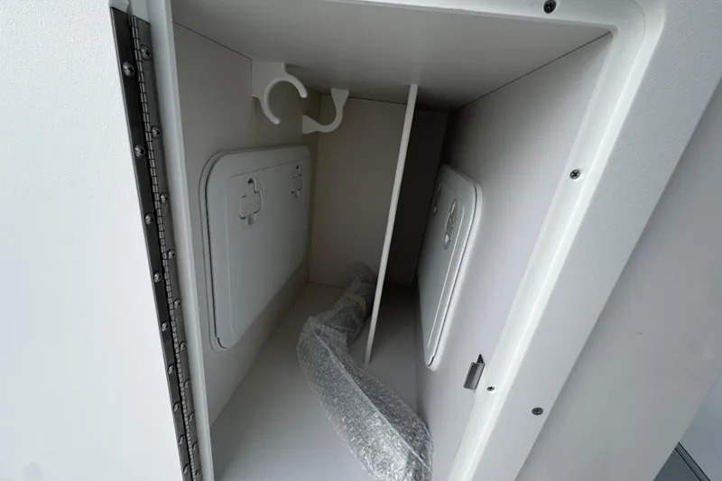 Slide: The Image of Storage compartment of 2026 Sea Pro 240 Dual Console boat, featuring secure hatch and bubble-wrapped item. - 8