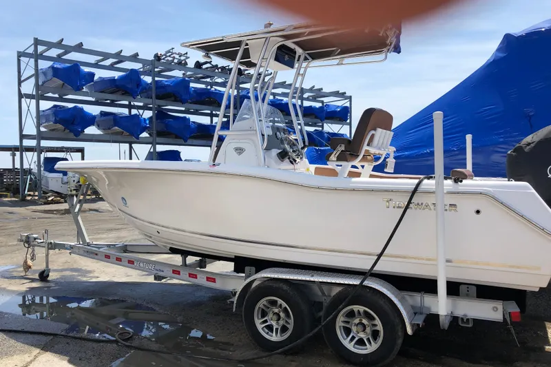 The Image of 2018 Tidewater 210 CC Adventure boat on trailer, marina background. - 0
