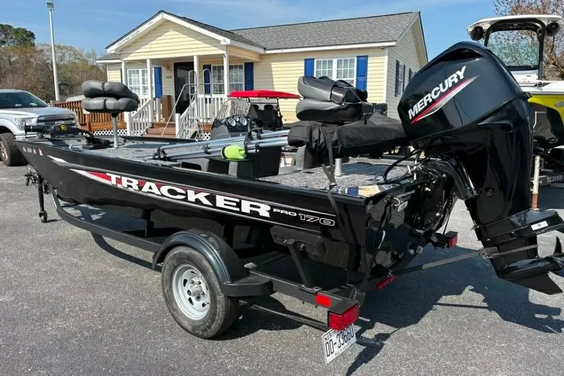Slide: The Image of 2025 Tracker Pro 170 boat with Mercury engine parked in front of a house. - 3