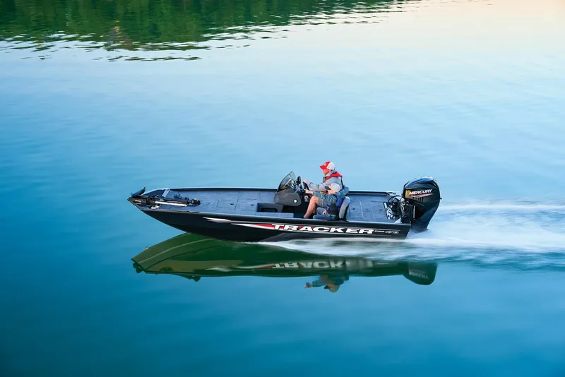 Slide: The Image of Manufacturer Provided Image: 2025 Tracker Pro 170 boat cruising on a calm lake with lush green shoreline. - 57
