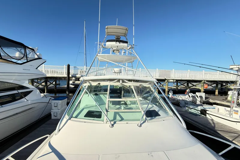 Slide: The Image of 1996 Cabo 35 Express boat docked at marina under clear blue sky. - 12
