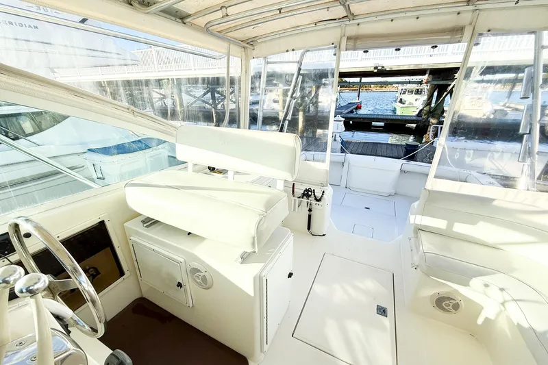 Slide: The Image of Interior view of a 1996 Cabo 35 Express boat with white seating and helm. - 14