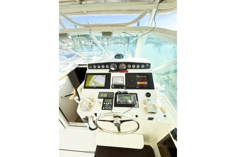 Slide: The Image of 1996 Cabo 35 Express boat helm with navigation equipment and steering wheel. - 16