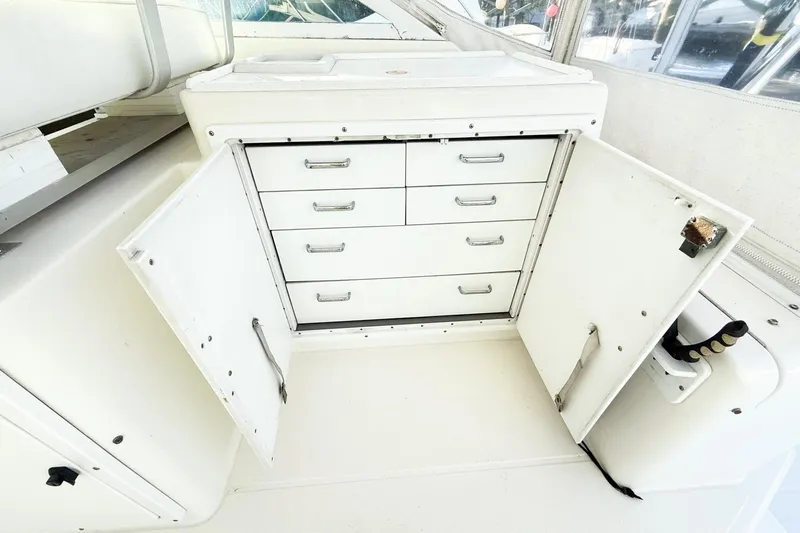 Slide: The Image of Open storage cabinet with drawers on a 1996 Cabo 35 Express boat. - 20