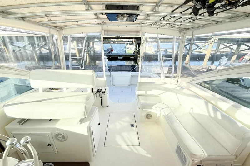Slide: The Image of Interior view of a 1996 Cabo 35 Express boat with white seating and fishing rods. - 21