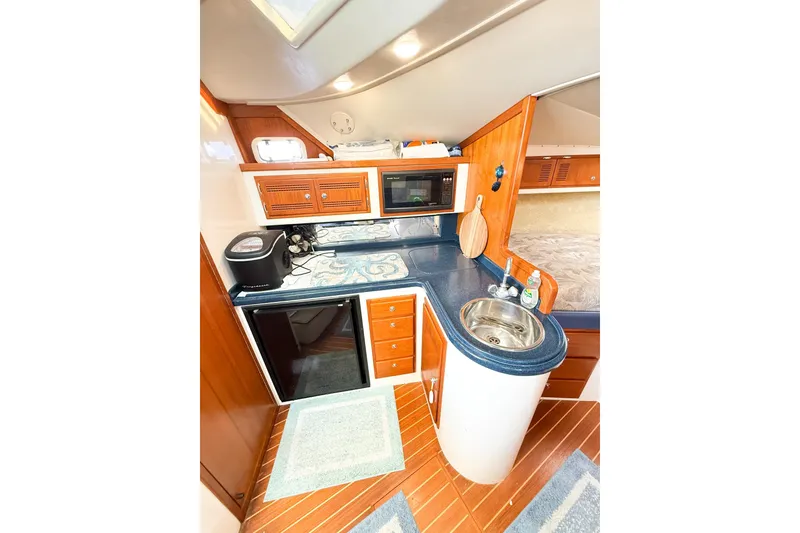 Slide: The Image of 1996 Cabo 35 Express yacht interior kitchen with wood cabinetry and modern appliances. - 25