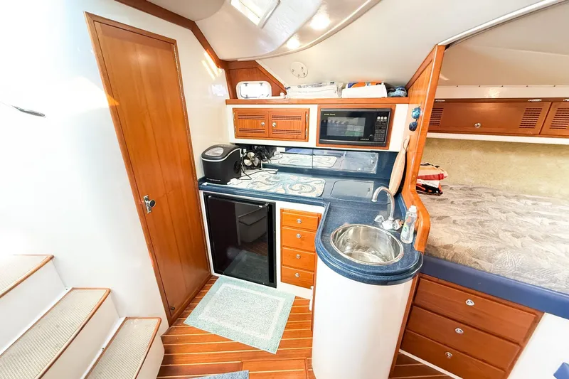 Slide: The Image of Interior of 1996 Cabo 35 Express yacht with kitchenette and wooden cabinetry. - 27
