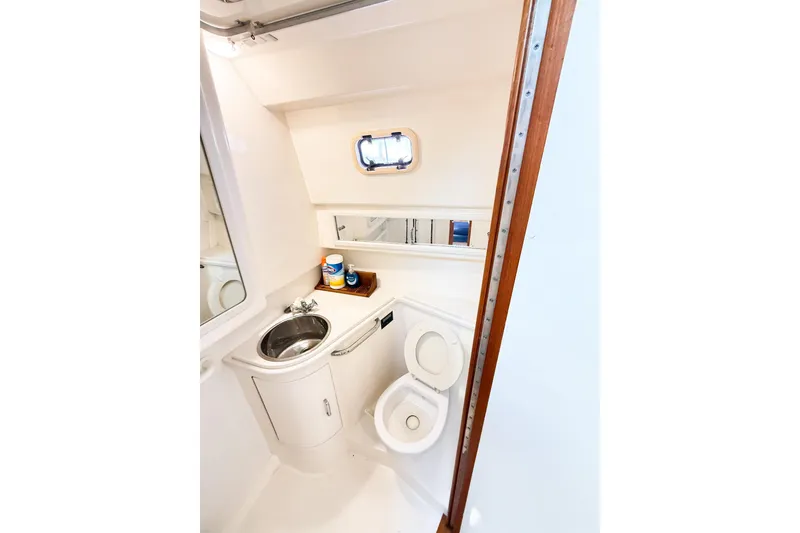 Slide: The Image of Bathroom interior of a 1996 Cabo 35 Express boat, featuring sink and toilet. - 29