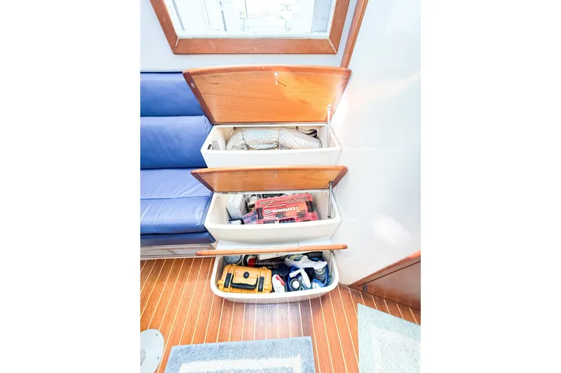 Slide: The Image of Storage compartments on a 1996 Cabo 35 Express boat with wooden accents and organized items. - 33