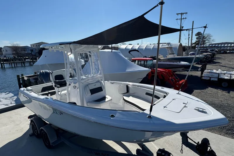 Slide: The Image of 2025 Tidewater 220 LXF boat docked, featuring sleek design and canopy, in a marina setting. - 12