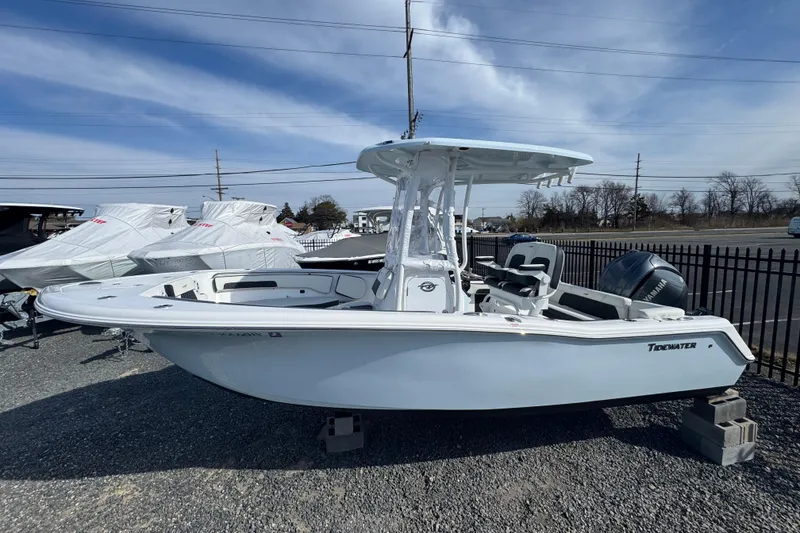 Slide: The Image of 2025 Tidewater 220 LXF boat displayed outdoors on a sunny day. - 2
