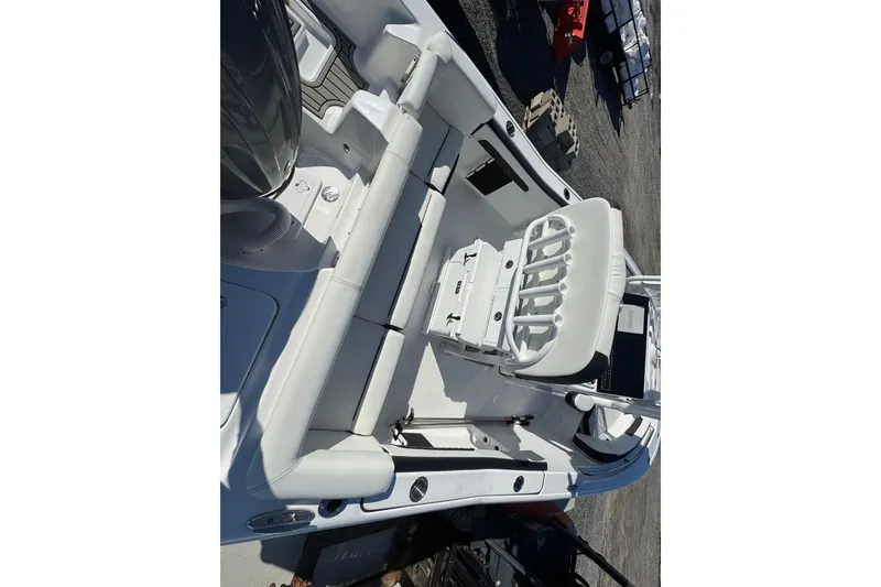 Slide: The Image of 2025 Tidewater 220 LXF boat interior with white seating and fishing rod holders. - 7
