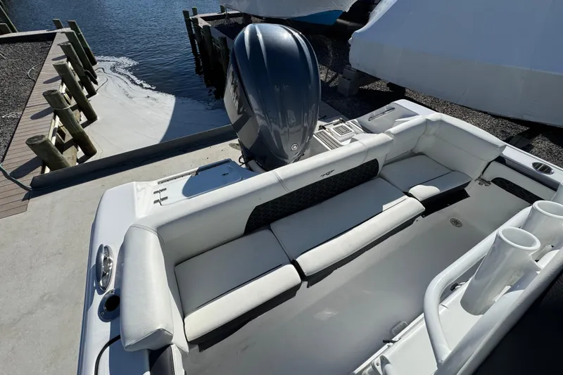 Slide: The Image of 2025 Tidewater 220 LXF boat with sleek seating and powerful outboard motor at dock. - 9
