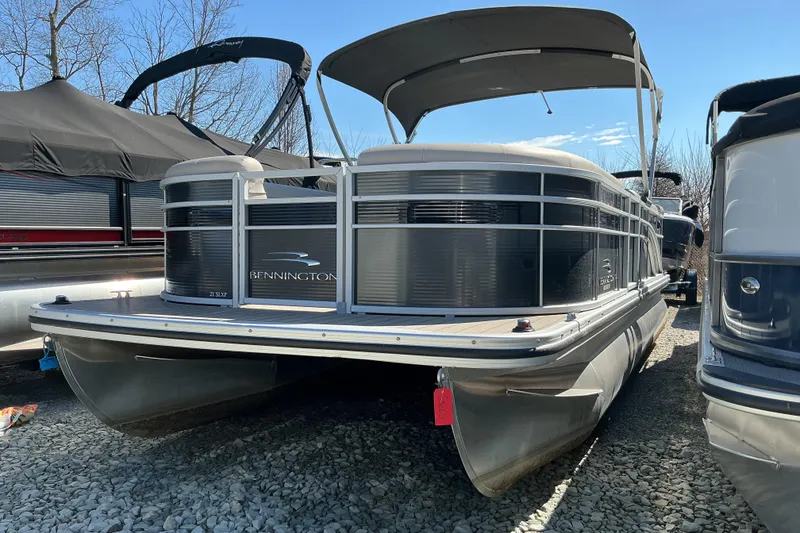 The Image of 2018 Bennington SX 21 SLXP pontoon boat with canopy, parked on gravel. - 1
